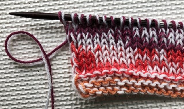 Small swatch of Felici (Pinwheel colorway) held double with Stroll Glimmer in White, on Size US 7 needles
