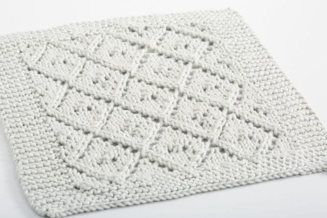 A gray knitted dishcloth with a diamond pattern.