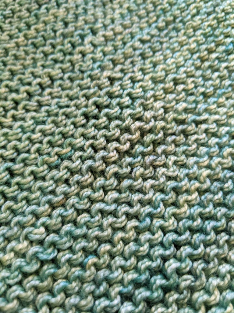 A large image of knitted garter stitch in green yarn.