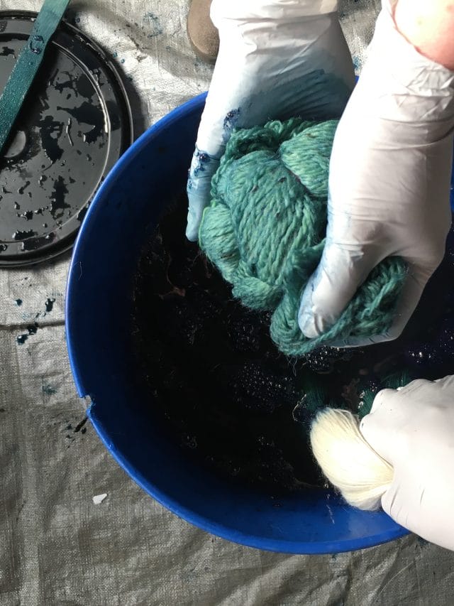 Hands Dyeing yarn with indigo