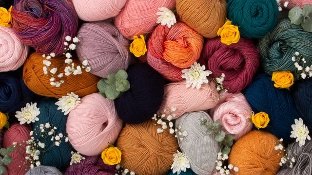 An image of a pile of yarn balls spiked with lots of flowers