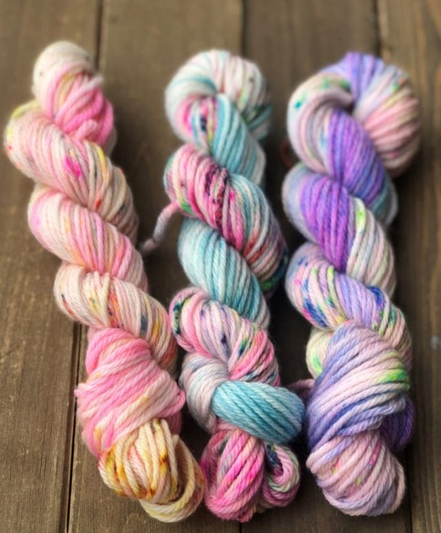 Three mini-skeins of yarn in neon speckled colorways.