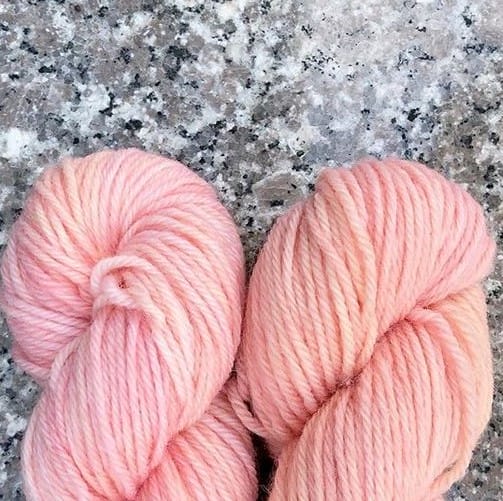 The ends of 2 pink skeins of yarn.