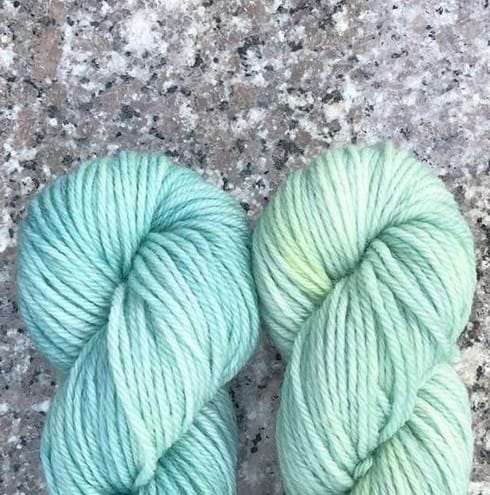 The ends of two pale green skeins of yarn.