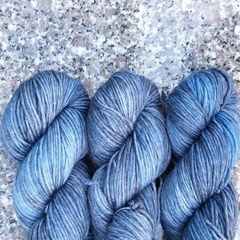 The ends of three blue skeins of yarn.
