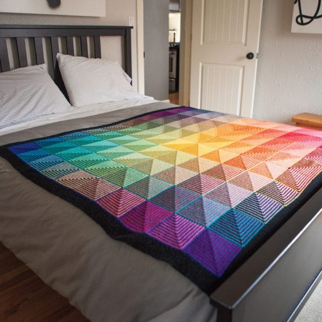 The Hue Shift Blanket spread out on a bed.