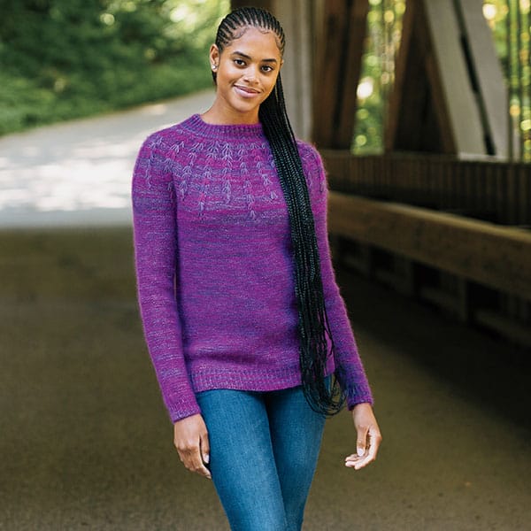 A model wears a pretty purple knitted sweater with a fan-like detail around the yoke. Sorrel by Wool + Pine, a new indie knitting pattern available at knitpicks.com.