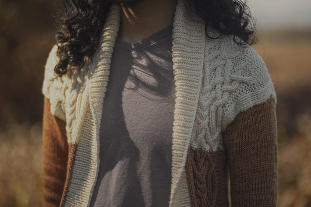 Regan models his coffee sweater, which is knitted in cream and brown yarn.