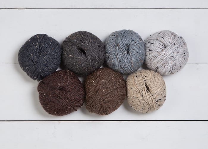 Seven balls of City Tweed DK, ranging in color from dark gray to brown to tan to cream.