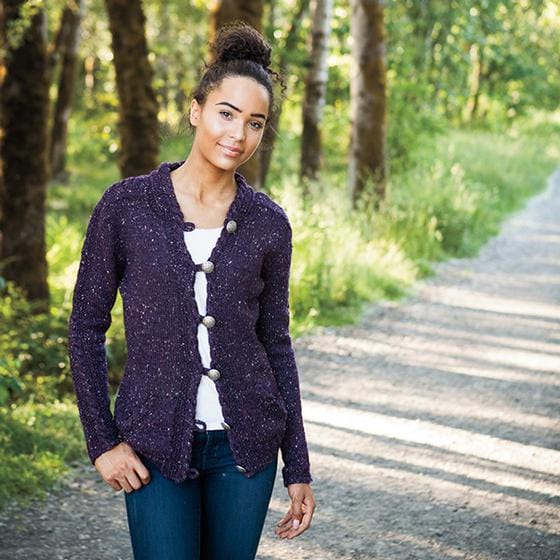 A model wears The Liana Cardigan, a knitted tweed cardigan in purple.
