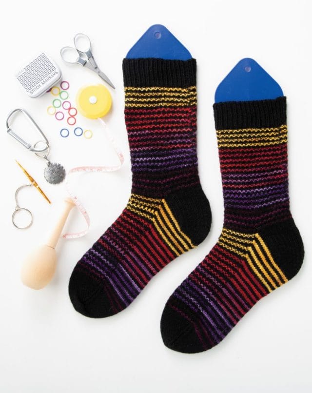 Phinney Ridge Socks -- knitted socks on sock blockers and accompanied by assorted knitting accessories