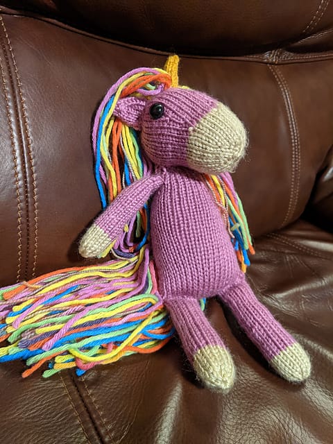 Nilla the Unicorn by Ravelry user dlgray31. A lavender knitted unicorn with a rainbow mane and tail.