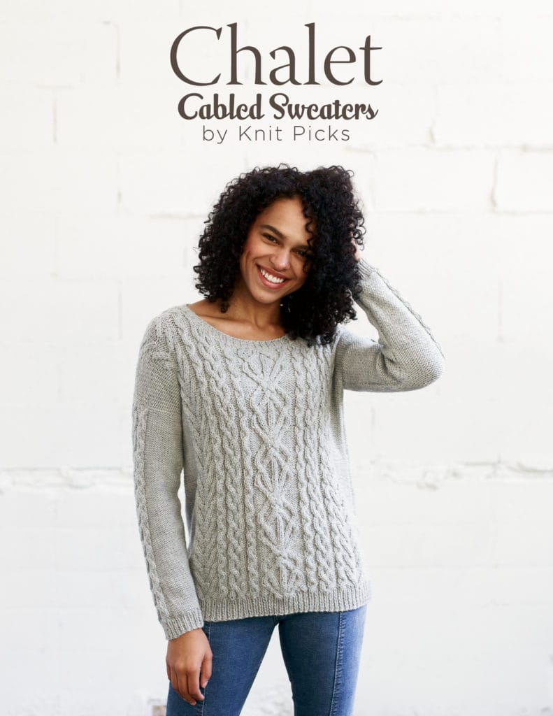 Book cover: text at the top - Chalet, Cabled Sweaters, by Knit Picks - and a photo of a woman modeling a light grey cabled sweater, with columns of cables running up the whole front of the body, including a wider, complex cable in the center, and cables running down the sleeves at the sides only. The woman is smiling and holding her left hand up to her curly hair, standing in front of a white background, and wearing blue jeans.