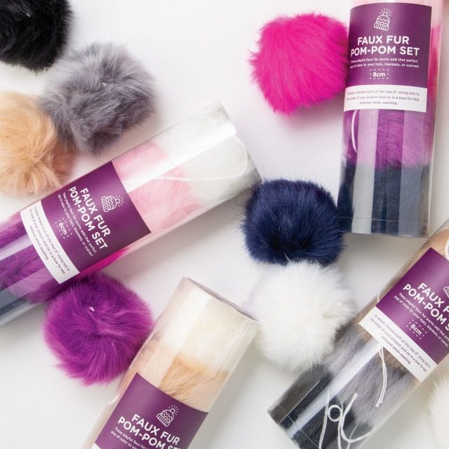 Colorful faux fur pom pom sets on a white background.