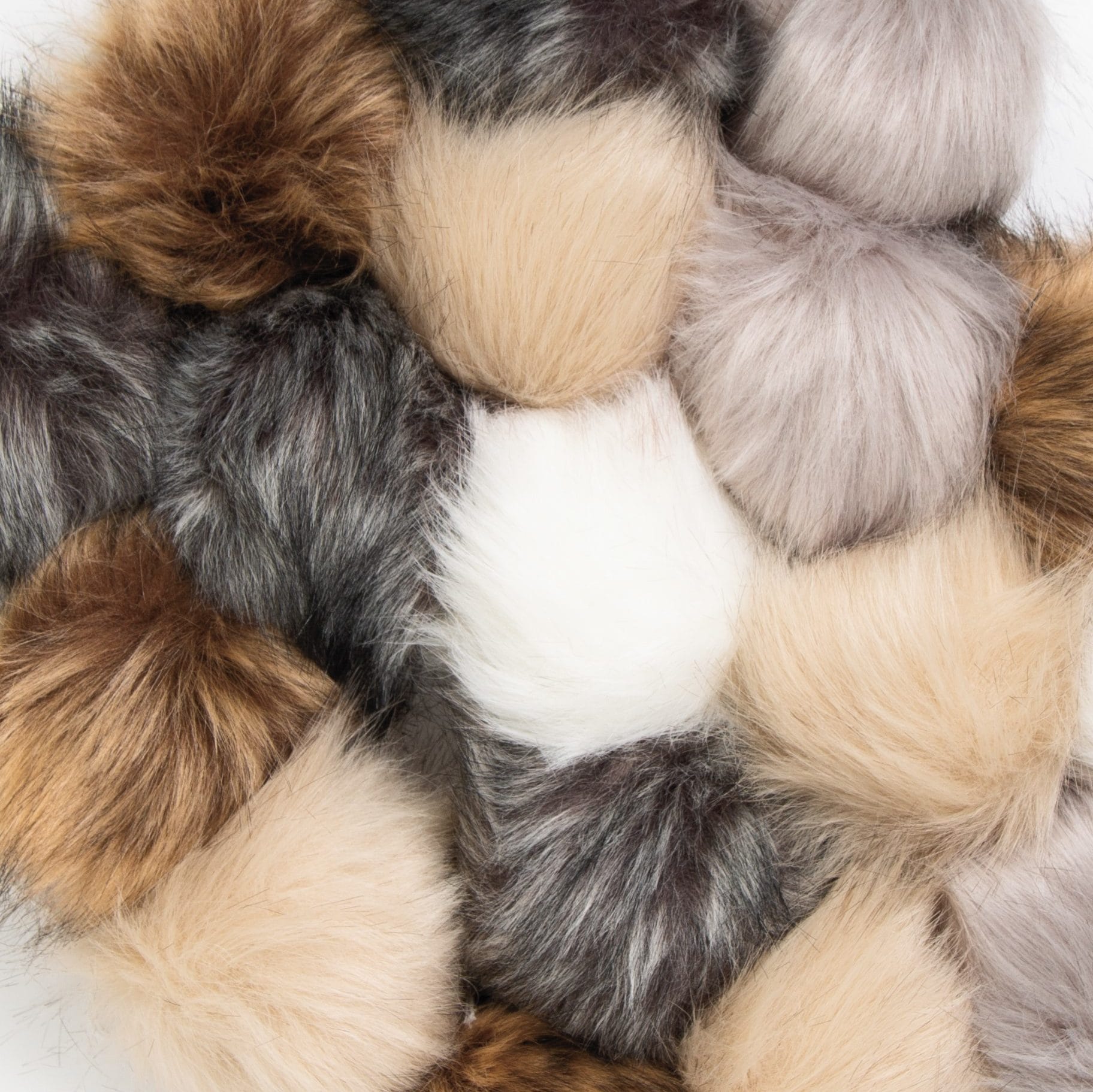 A pile of neutral colored faux fur pom poms.