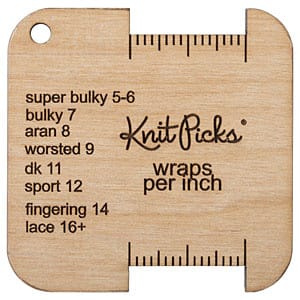 A wooden Wraps Per Inch tool with a spot for wrapping yarn to determine its weight. There's a legend on the tool that says "super bulky 5-6, bulky 7, aran 8, worsted 9, dk 11, sport 12, fingering 14, lace 16+ and also the Knit Picks logo and the words "wraps per inch"