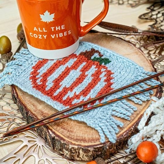 a mug rug knitted with an image of a pumpkin