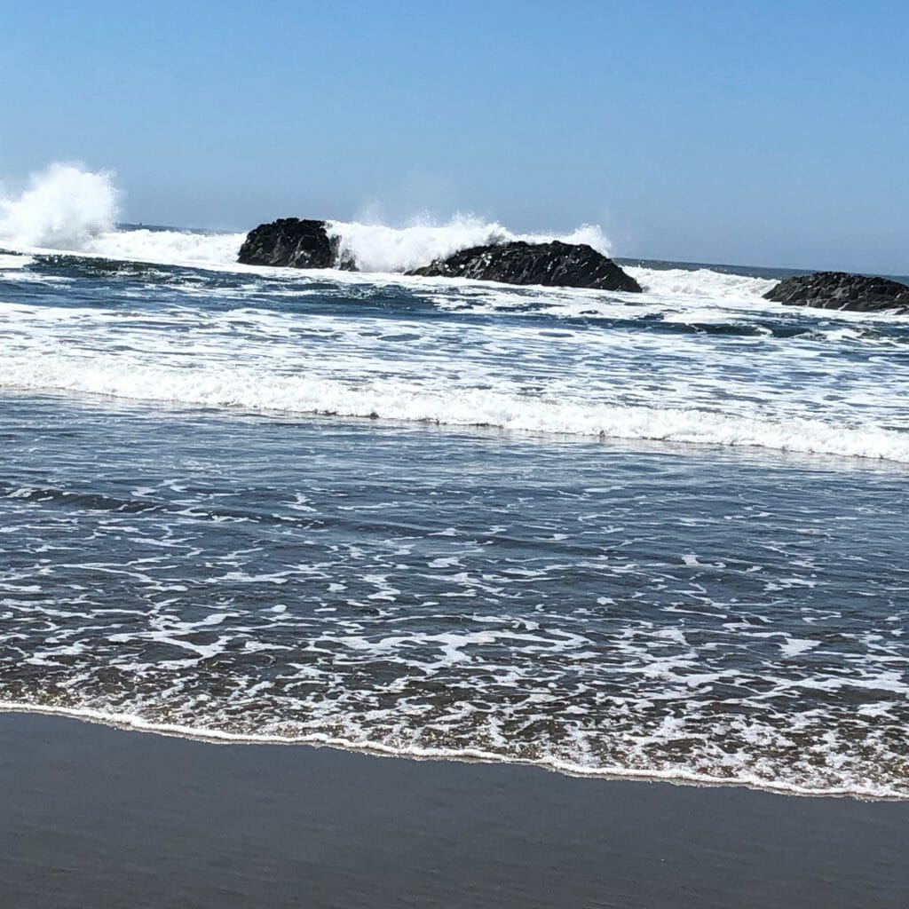 Ocean waves hit large rocks off the coast.