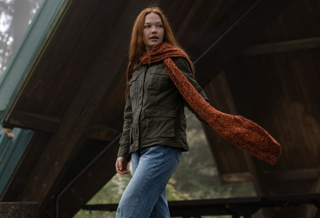 A woman wears a long, cabled scarf.