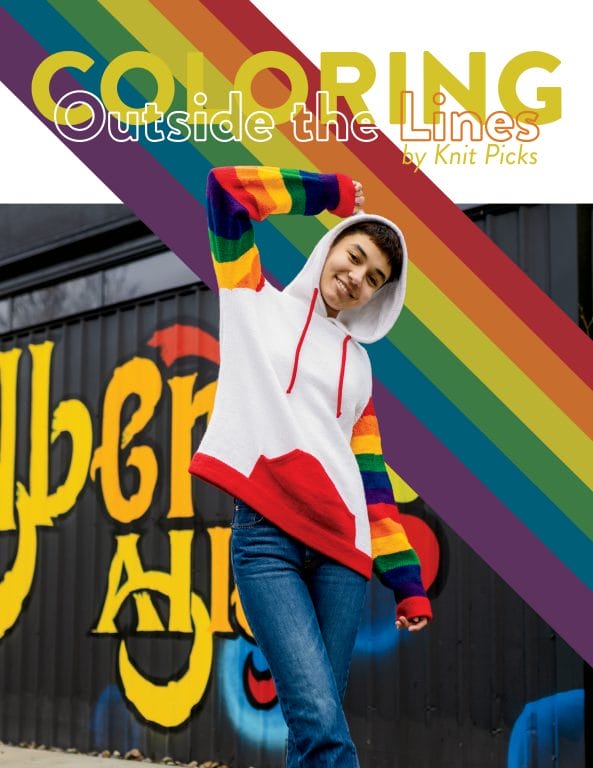Una mujer joven lleva una sudadera con capucha con un cuerpo blanco y mangas de arcoíris.  Encima de su texto se lee " Colorear fuera de las líneas"