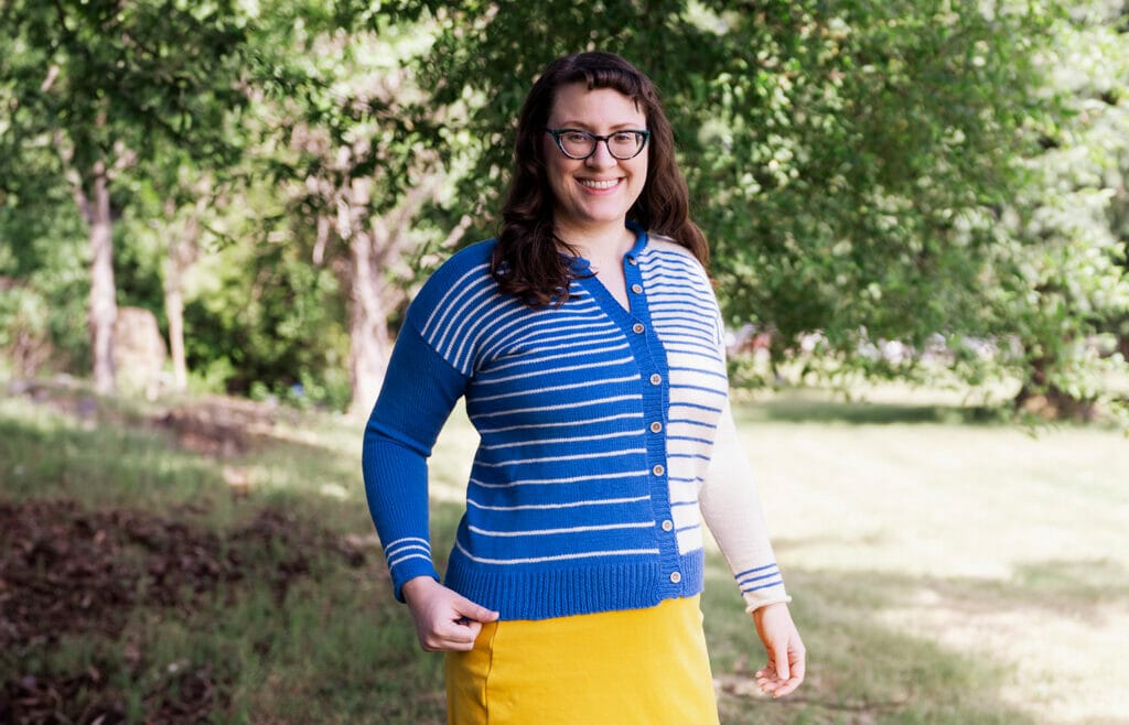 A plus-sized white woman wears a snug cardigan. 