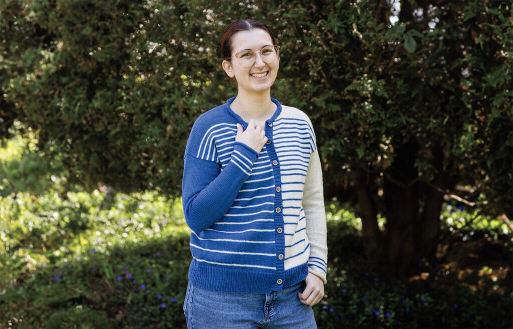 A small white woman wears a loose cardigan