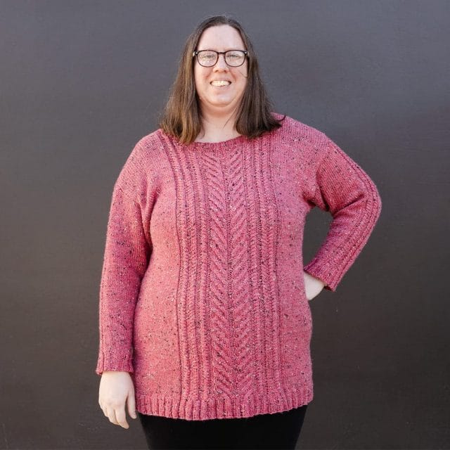 A woman wearing a pink cabled sweater